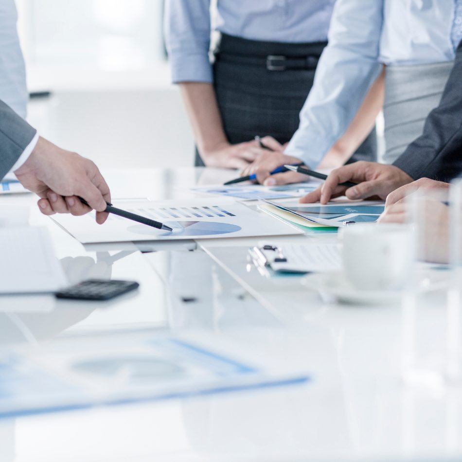Equipo de profesionales analizando informes financieros en una mesa de reunión